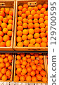An abundant pile of fresh oranges. Fruits on a market stall. Eco food, vegetarian lifestyle, organic nutrition, and healthy eating. 129700595