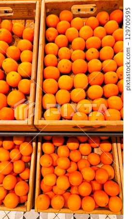 An abundant pile of fresh oranges. Fruits on a market stall. Eco food, vegetarian lifestyle, organic nutrition, and healthy eating. An abundant pile of fresh oranges. Fruits on a market stall. Eco food, vegetarian lifestyle, organic nutrition, and healthy eating. 129700595
