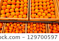 An abundant pile of fresh oranges. Fruits on a market stall. Eco food, vegetarian lifestyle, organic nutrition, and healthy eating. 129700597