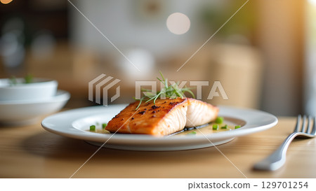 Delicious pan seared salmon served on a white plate in an elegant restaurant setting prepared for a culinary experience 129701254