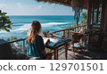 Artist sketching by the ocean on a tropical terrace with inspiring sea views 129701501