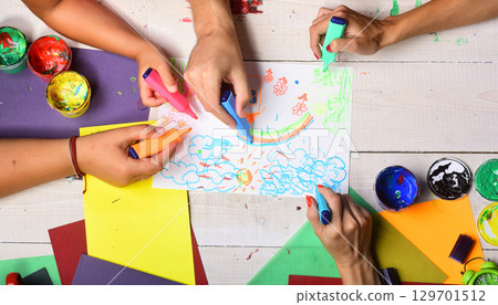 Markers in male and female hands draw on white paper 129701512