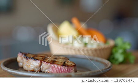 Delicious grilled beef steak with fresh vegetables served on a plate in a restaurant setting Delicious grilled beef steak with fresh vegetables served on a plate in a restaurant setting 129702473