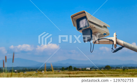 Surveillance Camera on Metal Rail with Blurred Fields Surveillance Camera on Metal Rail with Blurred Fields 129702755