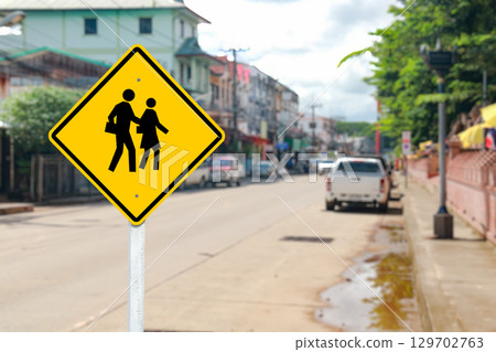 Yellow Pedestrian School Crossing Sign with Blurred Street 129702763