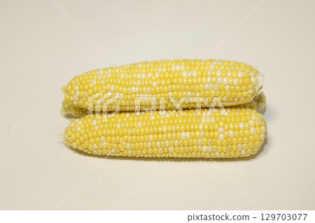 Three raw cobs of sweet corn against background. Tasty sweet corn on cobs 129703077