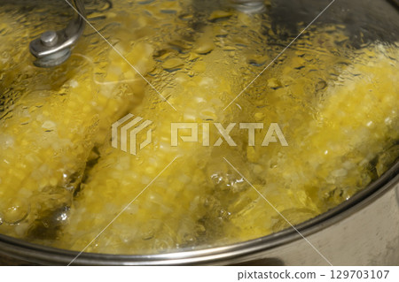 Cobs of sweet corn in a pot of water boiled. Cooking sweet corn in saucepan. Tasty corn on cobs Cobs of sweet corn in a pot of water boiled. Cooking sweet corn in saucepan. Tasty corn on cobs 129703107