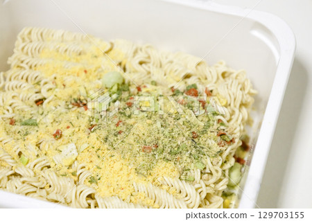 Raw instant noodles with spices on white plastic box. Raw instant noodles with spices on white plastic box. 129703155