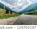 Summer mountain landscape with an asphalt road in the Solkpass pass in Austria. Panoramic view of alpine nature, green slopes and blue sky. 129703197