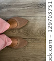 Stylish footwear worn with pastel pants on a wooden floor in a bright indoor setting 129703751