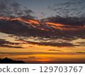 Stunning sunset over the horizon with vibrant colors reflecting on the clouds 129703767