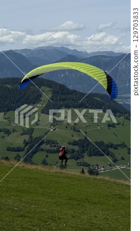Paraglider Soaring Over Scenic Mountain Landscape Paraglider Soaring Over Scenic Mountain Landscape 129703833