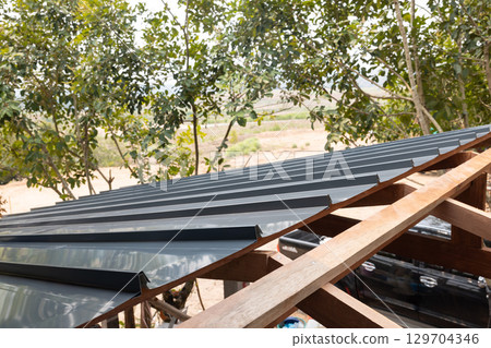 Roof under construction with metal sheet and wood structure. Roof under construction with metal sheet and wood structure. 129704346