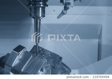 The 5-axis CNC milling machine finish cut the mold part with solid ball nose end mill tool in blue tone scene. The 5-axis CNC milling machine finish cut the mold part with solid ball nose end mill tool in blue tone scene. 129704494