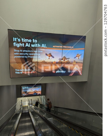 Gary Reed International Airport, Las Vegas, Nevada, USA - August 3, 2024: Escalator with advertising boards at the exit of the airport. 129704763