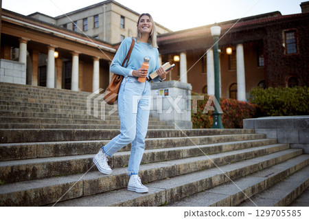 Woman, student on campus stairs and university, education with learning and academic goals with scholarship outdoor. Books for reading, study and happy person with success, college life and studying 129705585
