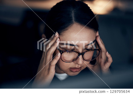 Headache, stress and business woman at night working on computer for project, report and strategy deadline. Burnout, mental health and female worker in dark office frustrated, tired and overworked 129705634