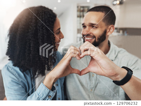 Love, heart hand sign and happy couple enjoy quality time together, bonding and relax on home living room sofa. Eye contact, emoji gesture and marriage people, man or woman smile in good health 129706232