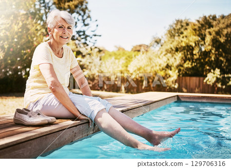 Senior woman with her feet in the pool while on a vacation, adventure or outdoor trip in summer. Happy, smile and elderly lady in retirement relaxing by swimming pool at a holiday resort in Australia Senior woman with her feet in the pool while on a vacation, adventure or outdoor trip in summer. Happy, smile and elderly lady in retirement relaxing by swimming pool at a holiday resort in Australia 129706316