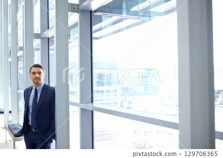 Vision, mindset and window with a business man at work, standing in his office while thinking of an idea. Corporate, growth and future with a male employee leaning against a glass wall while working 129706365