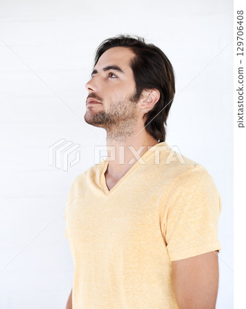 Casual, thinking and man looking up in a studio while being thoughtful or wondering for an idea. Pensive, daydreaming and young male model from Canada with stylish tshirt isolated by white background Casual, thinking and man looking up in a studio while being thoughtful or wondering for an idea. Pensive, daydreaming and young male model from Canada with stylish tshirt isolated by white background 129706408