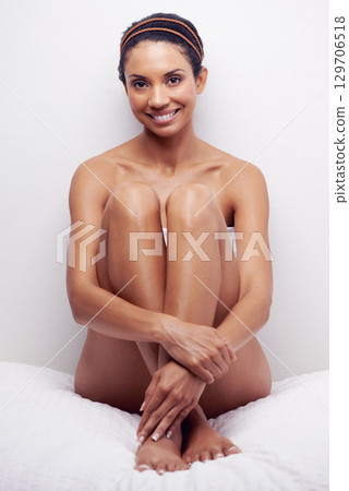 Happy, skincare and portrait of a woman on a bed advertising beauty, cosmetics and calm body. Smile, skin care and dermatology model marketing self care, skin grooming and smooth skin in a bedroom Happy, skincare and portrait of a woman on a bed advertising beauty, cosmetics and calm body. Smile, skin care and dermatology model marketing self care, skin grooming and smooth skin in a bedroom 129706518
