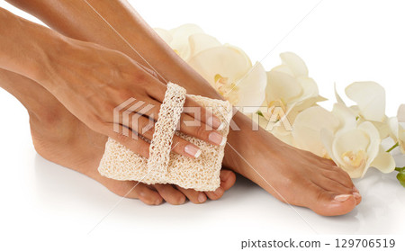 Feet, beauty spa and pedicure with a foot scrub for a woman in studio with flowers for luxury skincare. Toes and hands of wellness model for self care, cleaning and dermatology cosmetics in studio Feet, beauty spa and pedicure with a foot scrub for a woman in studio with flowers for luxury skincare. Toes and hands of wellness model for self care, cleaning and dermatology cosmetics in studio 129706519
