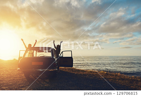 Friends, silhouette and sunset at beach with car, sky and hands in air for freedom, celebration and happy. Summer sunshine, holiday and ocean with vintage suv, travel and women by waves for happiness 129706815