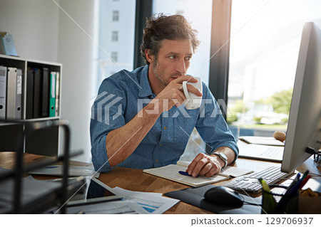 Coffee, thinking and computer with a business man at work in his office for future growth or research. Idea, tea and internet with a male employee working or planning online using a desktop 129706937