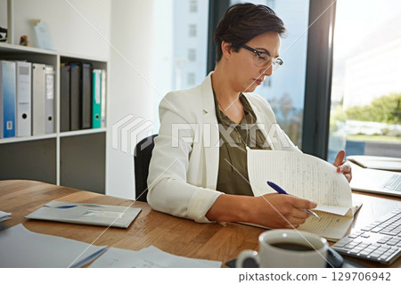 Business, woman and reading paperwork, focus and planning for marketing campaign, strategy and modern office. Corporate, female employee and entrepreneur with documents, notes and writing for ideas Business, woman and reading paperwork, focus and planning for marketing campaign, strategy and modern office. Corporate, female employee and entrepreneur with documents, notes and writing for ideas 129706942