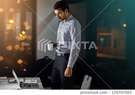 Laptop, coffee and night businessman reading feedback review of financial portfolio, stock market or investment. Online economy research, bokeh and crypto trader trading nft, forex or bitcoin mining 129707005