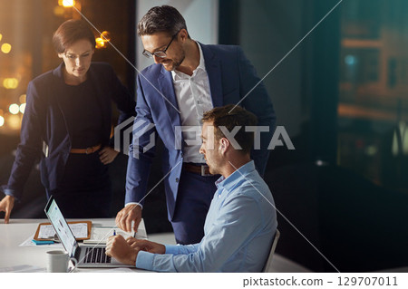 Business people, laptop and meeting working at night in office for big data collaboration, planning overtime and report deadline. Teamwork, late and digital tech conversation with web design leader 129707011
