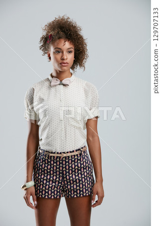 Fashion, style and clothes with a model black woman in studio on a gray background to promote a clothing brand. Summer, shorts and afro with an attractive young female on space for branding Fashion, style and clothes with a model black woman in studio on a gray background to promote a clothing brand. Summer, shorts and afro with an attractive young female on space for branding 129707133