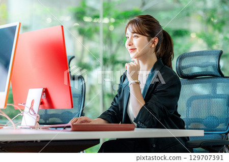 操作一台個人計算機的一個年輕女商人在辦公室 129707391