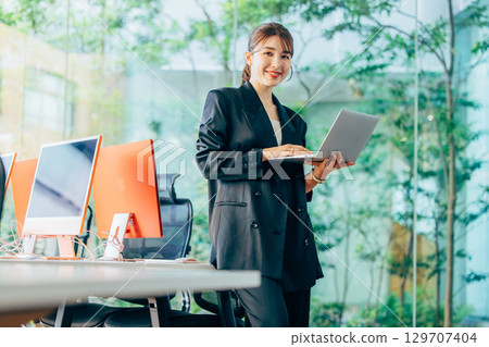Business woman operating a personal computer in the office Business woman operating a personal computer in the office 129707404