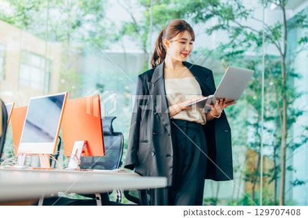 Business woman operating a personal computer in the office Business woman operating a personal computer in the office 129707408