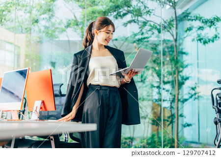 Business woman operating a personal computer in the office 129707412