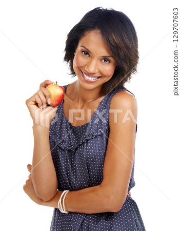 Portrait, food or black woman eating an apple in studio on white background with marketing mockup space. Smile, organic or happy African girl advertising healthy fruit diet for self care or wellness 129707603