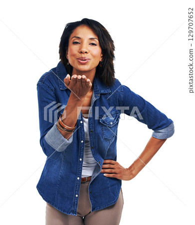 Portrait, love and blowing a kiss with a black woman in studio on a white background for romance or affection. Face, kissing and flirting with an attractive young female model standing hand on hip 129707652