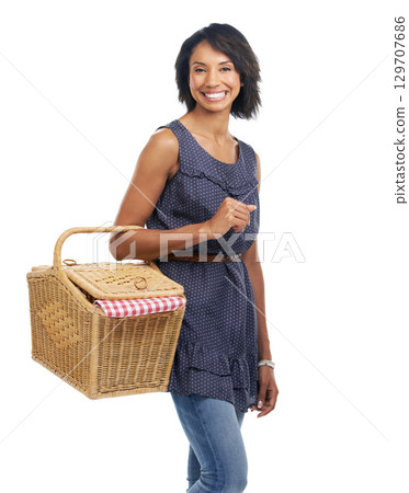 Picnic, happiness and portrait of black woman with basket and smile for summer weekend fun on white background. Fun, food and woman standing holding picnic basket, big smile, and excited in studio. 129707686