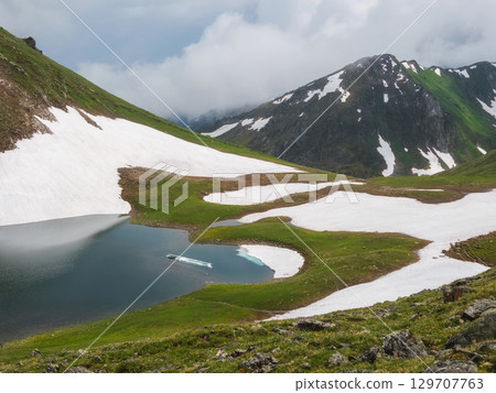 small glacial lake in a mountain valley small glacial lake in a mountain valley 129707763