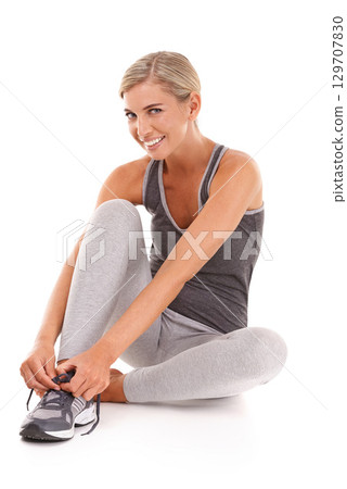 Fitness, portrait and woman tie shoes for training, smile and workout for wellness, health and girl isolated on white studio background. Female athlete, lady or runner tying sneaker lace and exercise 129707830