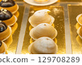 Assorted gourmet pastries displayed on a golden tray showcasing delightful textures and flavors 129708289
