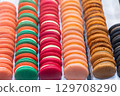 Colorful macarons arranged in neat rows showcasing vibrant hues and tempting textures for dessert lovers 129708290