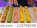 Colorful macarons displayed in a pastry shop with vibrant hues and tempting textures for dessert lovers 129708298