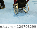 Individual in wheelchair navigating blue floor space with focus on mobility and independence 129708299