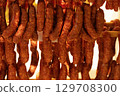 Hanging sausages drying in a warm environment with rich textures and appetizing colors 129708300