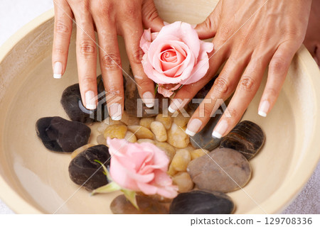 Spa, manicure and hands of a woman with rose flower and luxury wellness. Water, beauty and skincare of a model hand with roses and flowers aromatherapy for cosmetic skin care and cleaning indoor 129708336