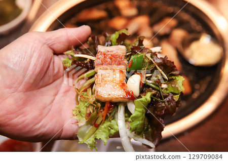 Korean bbq. ssam : eat pork wrapped in lettuce leaves Korean bbq. ssam : eat pork wrapped in lettuce leaves 129709084