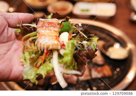 Korean bbq. ssam : eat pork wrapped in lettuce leaves 129709086